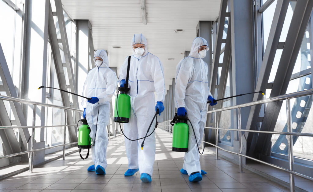 Three virologists carrying out treatments in a commercial building